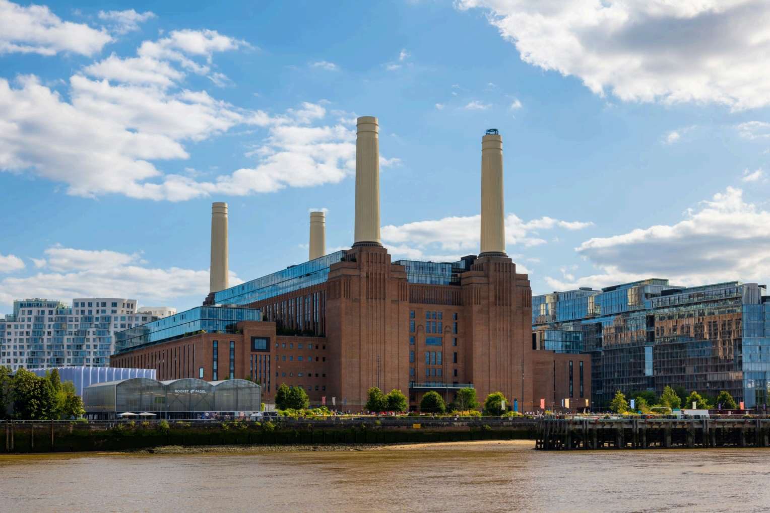 Battersea Power Station's brick building and four white chimneys viewed across the River Thames