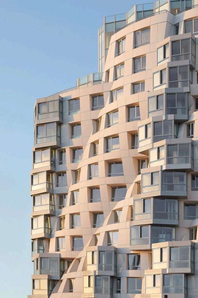 Detail of the sculpted stone and glass facade of an Electric Boulevard residential tower