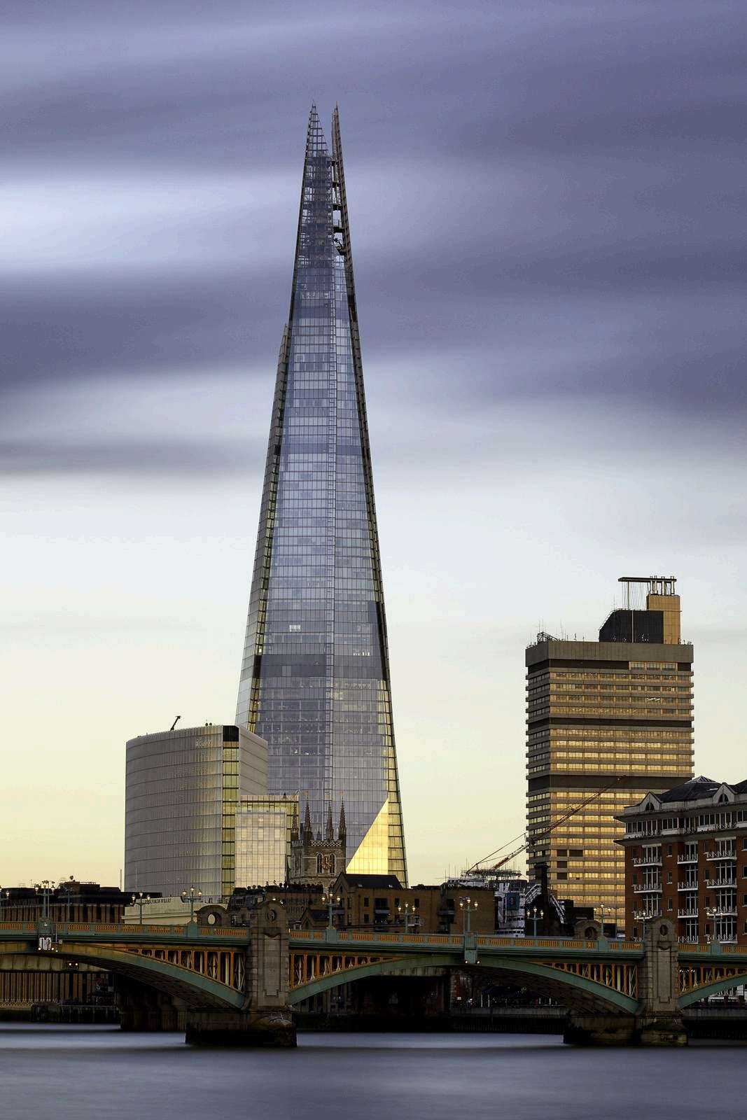 The Shard skyscraper rising above the London skyline at dusk, seen across the Thames