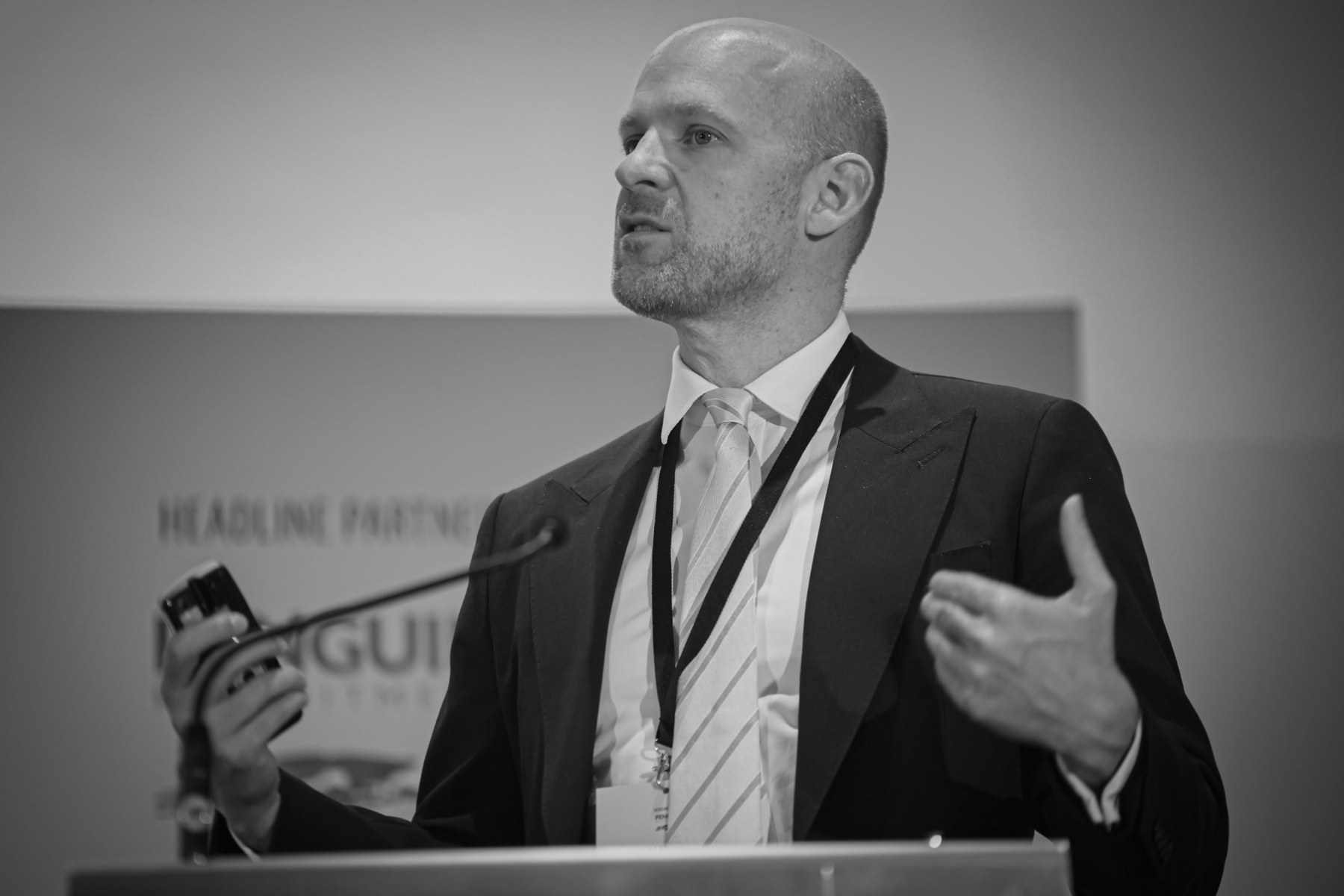 Black and white photograph of Gordon Adams delivering a keynote address at a lectern